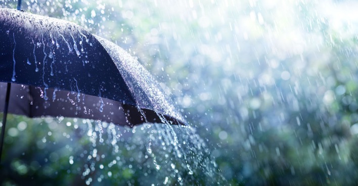 Starker Regen tropft von einem Schirm ab