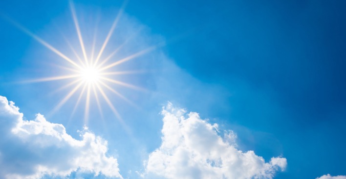 Himmel mit Sonne und wenigen Wolken.