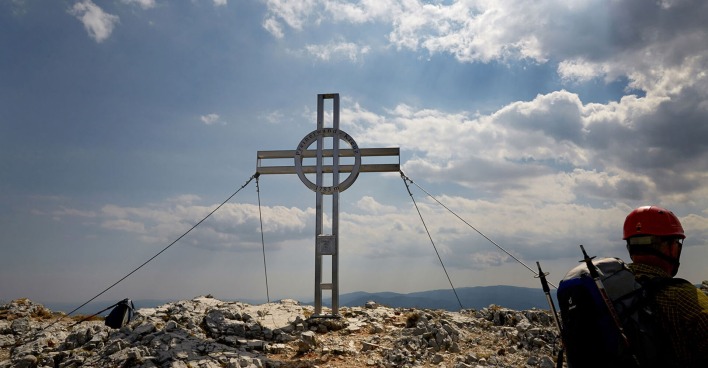 Kletterer steht am Gipfelkreuz | Credit: Hans Ringhofer / picturedesk.com