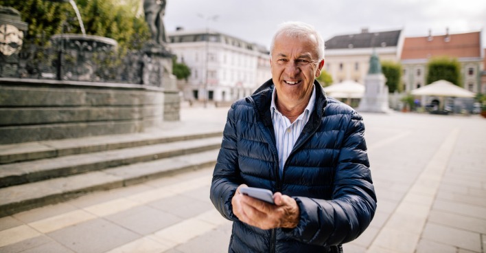 Mann probiert App am Handy vor Lindwurm Klagenfurt aus