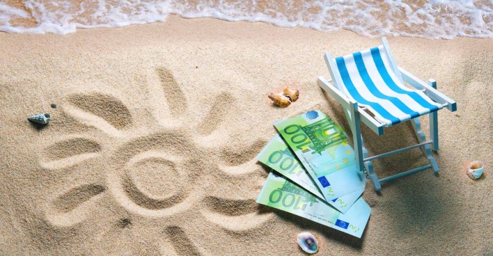 Euro-Scheine auf Sand mit Muscheln und einem Liegestuhl