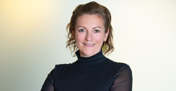 Porträt von Karina Winkler, die ein schwarzes Business-Outfit trägt