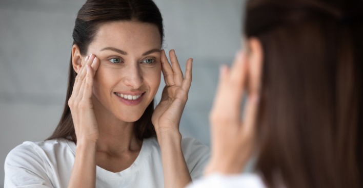 Frau blickt in den Spiegel | Credit: iStock.com/fizkes