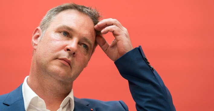 Andreas Babler bei einer Pressekonferenz vor der Pressewand der SPÖ. Er greift sich an den Kopf