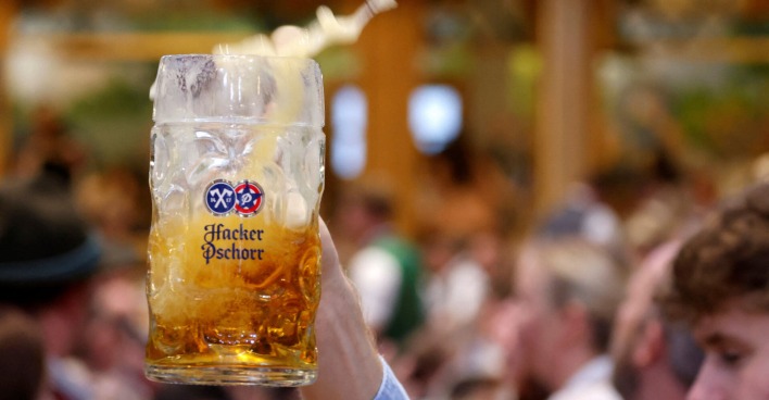 Jemand hält eine Maß Bier in einem Festzelt in die Höhe.