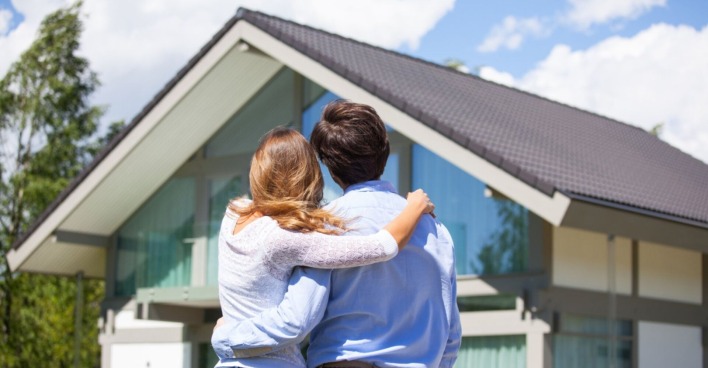 Ein Paar steht vor einem Haus | Credit: iStock.com/ALotOfPeople