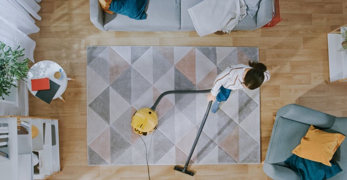 Frau saugt das Wohnzimmer | Credit: iStock.com/gorodenkoff