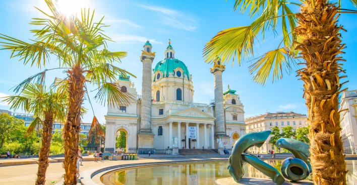 Palmen im Sonnenschein vor der Wiener Karlskirche | Credit: istock.com/arcady_31