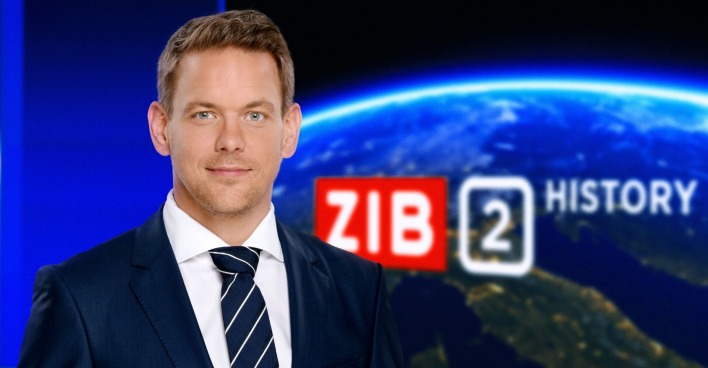 Offizielles Foto von Martin Thür als Moderator im Anzug im ZIB Studio. Im Hintergrund eingeblendet: ZIB2 History