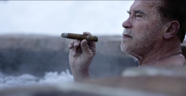Arnold Schwarzenegger mit Zigarre im Whirlpool.