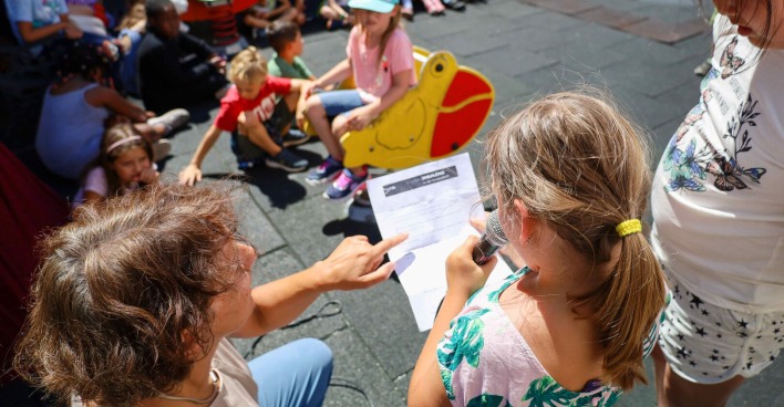Kinder, die spielen und einen Zettel ausfüllen