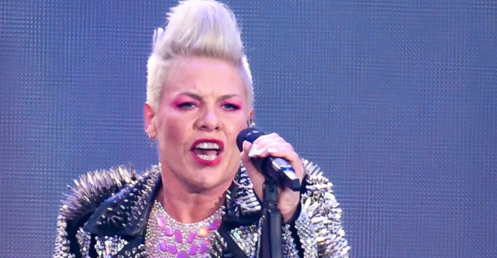 Eine Frau mit platinblonden Haaren singt in ein Mikrophon.