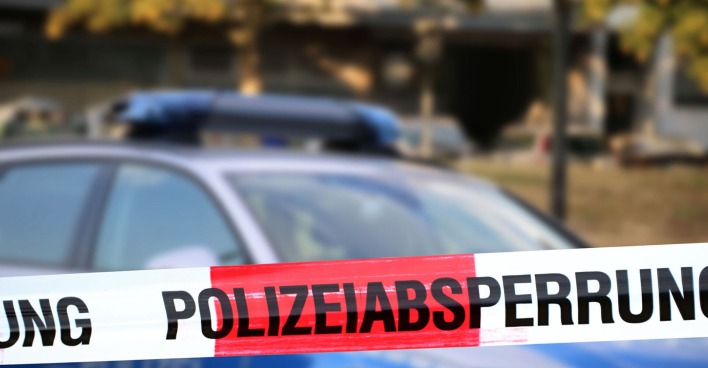 Polizeiabsperrung mit Polizeiauto im Hintergrund