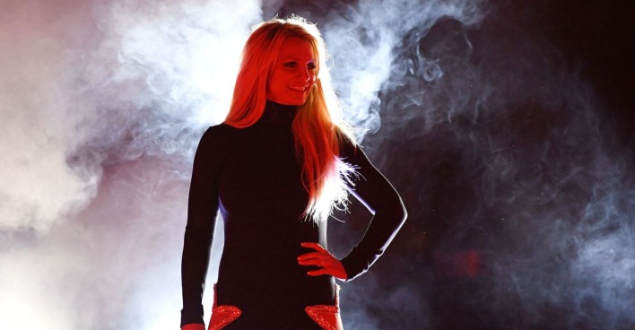 Britney Spears in einem schwarzen Kleid auf der Bühne.
