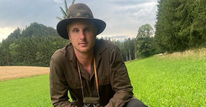 Martin Hinteregger posiert in Jagdkluft auf einer Wiese, er kauert im Gras