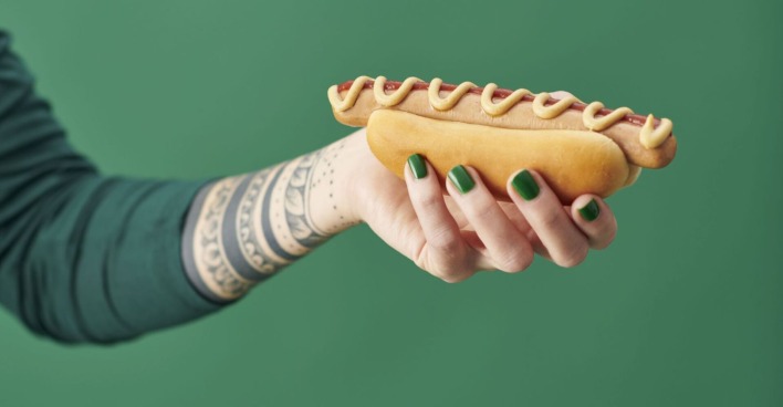 Eine Hand mit einem Hotdog.