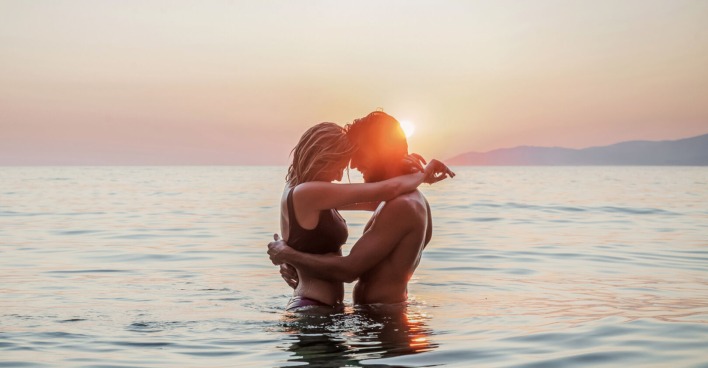 Verliebtes Paar beim Sonnenuntergang im Wasser