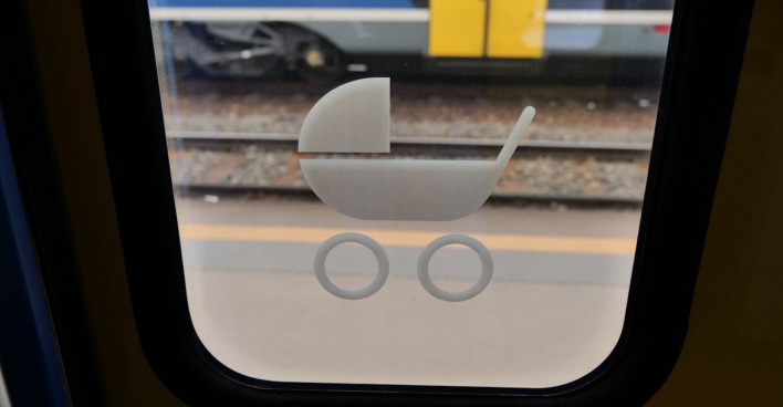 Ein Schild mit einem Kinderwagen auf einer Tür in einem Zug.
