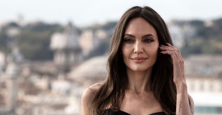 Angelina Jolie fährt sich mit der Hand durchs Haar.