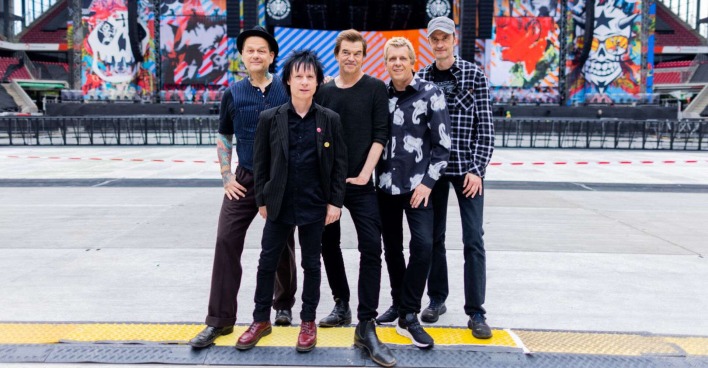 Die Toten Hosen stehen vor einer Bühne.