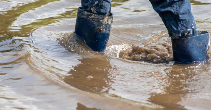 Mit Stiefeln in dreckigem Wasser