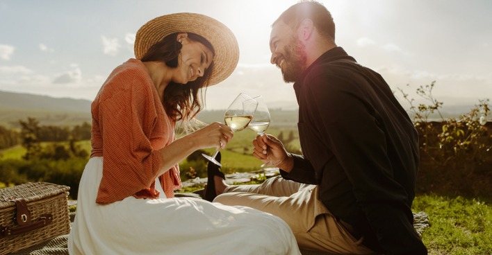 Paar trinkt Wein auf einer Wiese | Credit: iStock.com/jacoblund