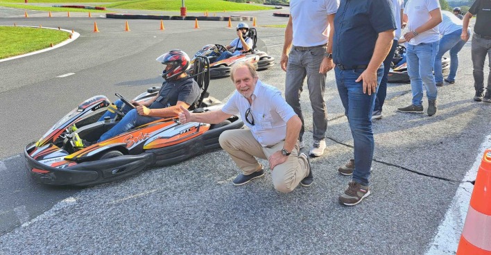 Personen stehend und kniend mit Go-Kart am Fahrsicherheitszentrum