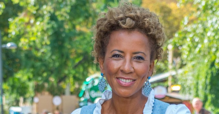 Arabella Kiesbauer vor einem begrünten Park