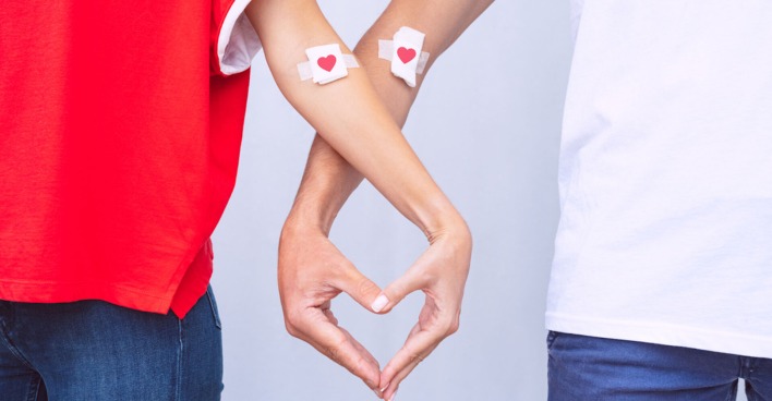 Zwei Blutspender mit Herzpflaster formen mit ihren Fingern ein Herz| Credit: istock.com/Daria Kulkova