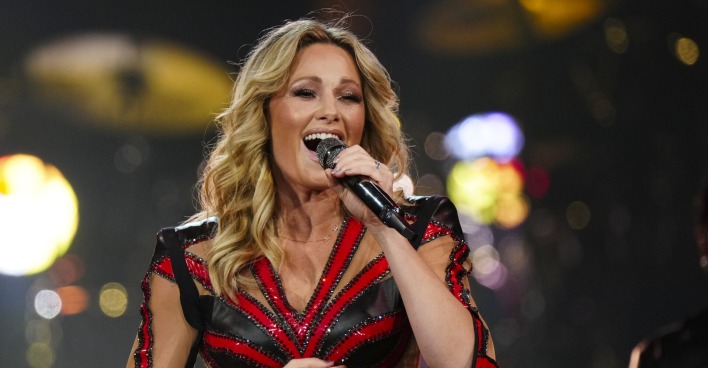 Helene Fischer singt in einem rot schwarzen Outfit mit einem Mikrofon in der Hand