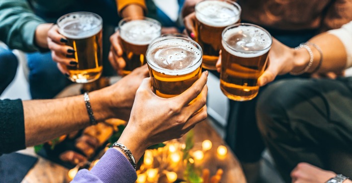 Mehrere Männder stoßen mit Bier an.