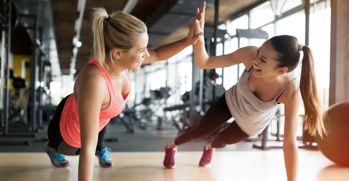 Trainerin in Fitnessstudio mit Frau