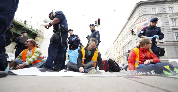 Klimakleber kleben auf der Straße. Polizisten sind vor Ort.