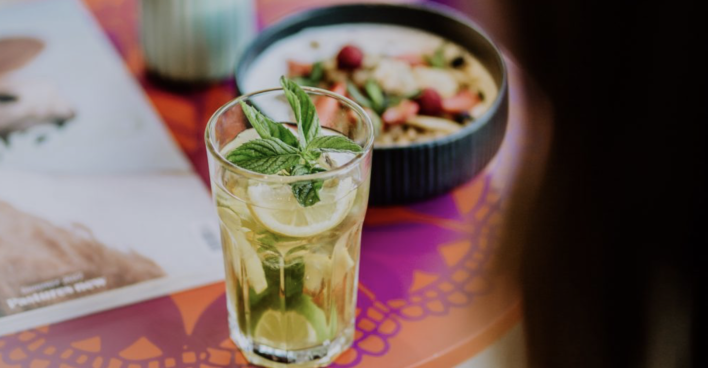 Glas Ingwerwasser mit Minze und eine Schüssel mit Müsli