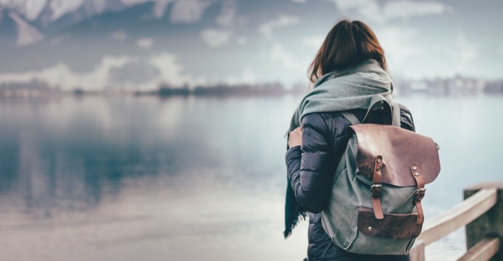 Frau mit Rucksack schaut auf einen See