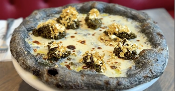 Eine Pizza mit violetten Rand, Blattgold und Kaviar.