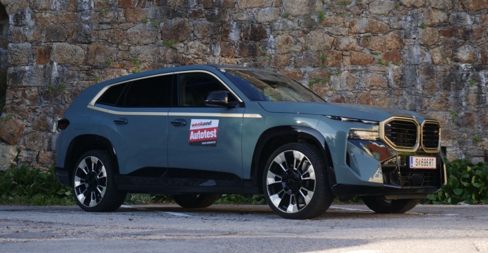 Die Beifahrerseite des BMW XM vor einer Steinmauer