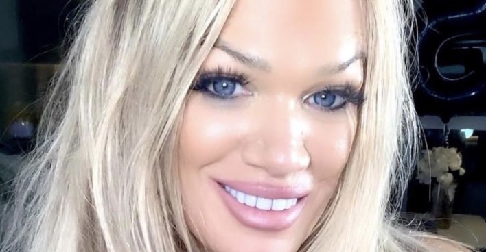 Eine blonde, starkgeschminkte Frau mit langen offenen Haaren.