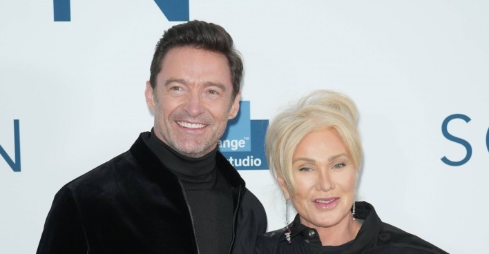 Hugh Jackman lächelt in die Kameras neben seiner Frau