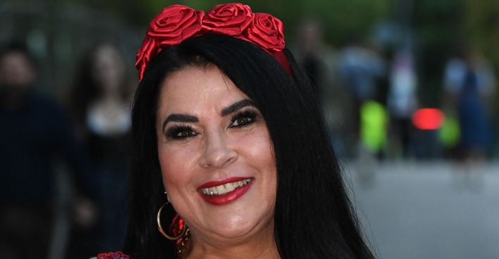 Iris Klein mit glatten schwarzen Haare und einem Rosenhaarreif.