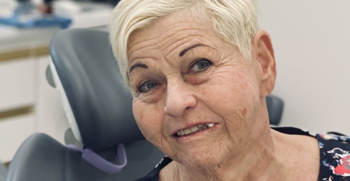 Sängerin Jazz Gitti mit kurzen blonden Haaren und einem Wattebausch im Mund beim Zahnarzt.