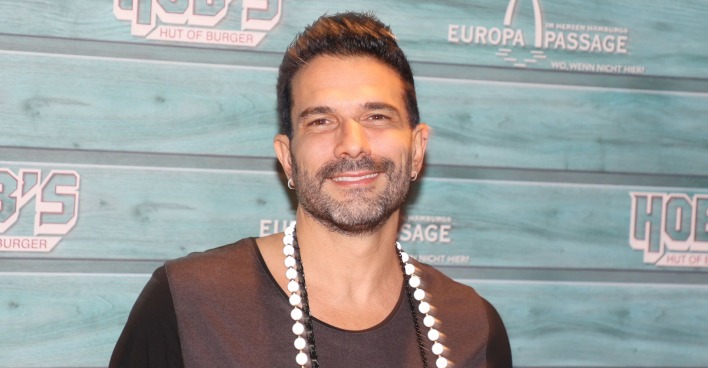 Marc Terenzi vor einer Fotoleinwand mit einer großen Kette.