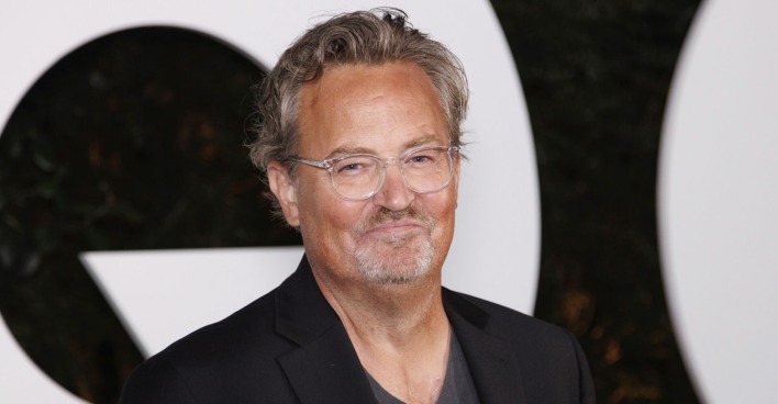 Matthew Perry beim CQ Award mit einem schwarzen Anzug und einer Brille.