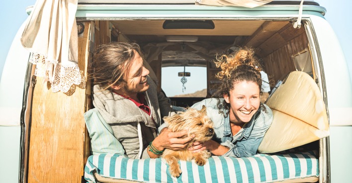 Paar fährt mit Hund surfen | Credit: iStock.com/ViewApart