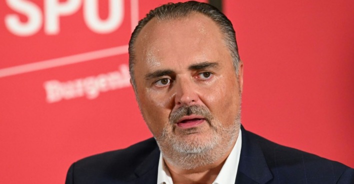 Hans Peter Doskozil im Porträt vor der Pressewand der SPÖ Burgenland