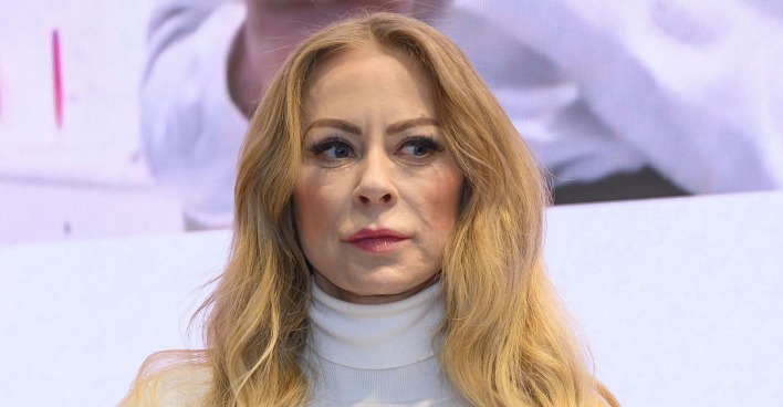 Jenny Elvers trägt einen weißen Rollkragenpulli und offene blonde, lange Haare.