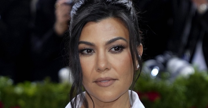 Kourtney Kardashian trägt hochgeschlossene schwarze Haare. Sie steht auf dem roten Teppich.