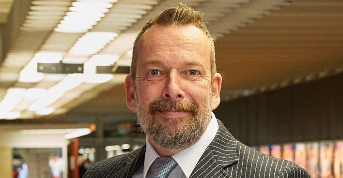 Robert Kratky steht im ORF Zentrum. Er trägt einen gestreiften Anzug.