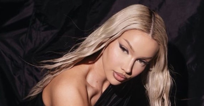 Shirin David trägt offene, platinblonde, lange Haare und ein starkes Augen Make-Up.