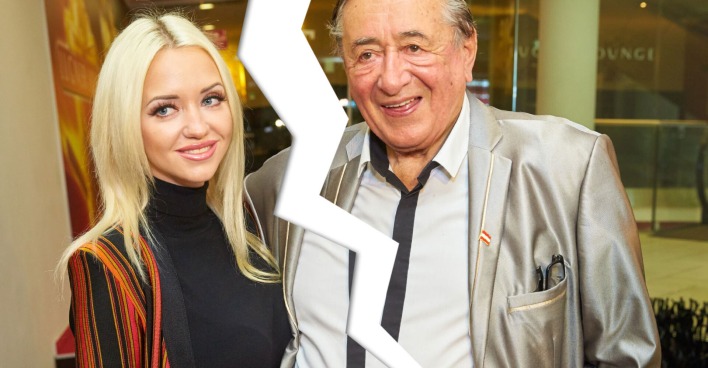 Cathy Lugner trägt einen gestreiften Blazer und steht neben Richard Lugner, er trägt einen grauen Blazer. Beide werden aufgrund der Streiterein von einem Blitz getrennt.
